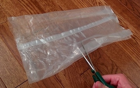 cutting-plastic-bag Scissors cut through plastic cereal bag.